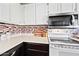 Clean kitchen counter with white cabinetry, tile backsplash, and modern appliances at 930 N Mesa Dr # 1079, Mesa, AZ 85201