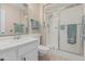 Bathroom featuring a glass-enclosed shower, a white vanity with modern fixtures, and neutral tiling at 9606 W Long Hills Dr, Sun City, AZ 85351