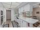 Functional kitchen features white cabinets, ample counter space and neutral tile flooring at 9606 W Long Hills Dr, Sun City, AZ 85351