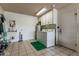 This laundry room has a side-by-side washer and dryer, ample storage cabinets, and a utility sink at 9606 W Long Hills Dr, Sun City, AZ 85351
