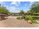 Lush backyard featuring a stunning pool with waterfall features, outdoor kitchen, putting green, and desert landscaping at 9936 E Winter Sun Dr, Scottsdale, AZ 85262