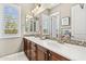 Bathroom featuring double sink vanity, decorative tile backsplash, and plantation shutters at 9936 E Winter Sun Dr, Scottsdale, AZ 85262
