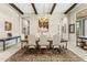 Formal dining room with wood beams, designer chandelier, and seating for six under an elegant rug at 9936 E Winter Sun Dr, Scottsdale, AZ 85262