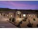 Stunning home exterior showcases desert landscaping, stone accents, and a tile roof under a vibrant sunset sky at 9936 E Winter Sun Dr, Scottsdale, AZ 85262