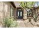 Inviting front entrance featuring an iron double door, desert landscaping, and a paver walkway at 9936 E Winter Sun Dr, Scottsdale, AZ 85262