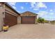 Three car garage with stone accents and desert landscaping at 9936 E Winter Sun Dr, Scottsdale, AZ 85262