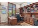 Dedicated office with custom built-in bookshelves, ample desk space, and a large window providing plenty of natural light at 9936 E Winter Sun Dr, Scottsdale, AZ 85262