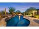 Inviting backyard pool with waterfall feature and adjacent fire pit provides a relaxing outdoor oasis at 9936 E Winter Sun Dr, Scottsdale, AZ 85262