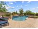 Beautiful backyard pool with a tiled waterfall feature, stone accents, and lounge chairs for ultimate relaxation at 9936 E Winter Sun Dr, Scottsdale, AZ 85262
