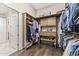 Well-organized walk-in closet with custom wooden shelves, offering extensive storage space for a variety of clothing and accessories at 9936 E Winter Sun Dr, Scottsdale, AZ 85262