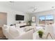 Bright living room with a large window, neutral decor, and comfortable white furniture at 11203 E Crescent Ave, Mesa, AZ 85208