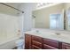 Well-lit bathroom featuring a dual sink vanity, shower-tub, and a large mirror at 11625 N 153Rd Dr, Surprise, AZ 85379