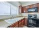 Close-up of kitchen with granite countertops, wood cabinets, and black appliances at 11625 N 153Rd Dr, Surprise, AZ 85379