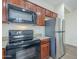 A kitchen showcasing wood cabinets, stainless steel refrigerator, granite countertops, and black oven at 11625 N 153Rd Dr, Surprise, AZ 85379