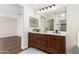 Bathroom featuring a double sink vanity with dark wood cabinets, framed mirrors, and modern fixtures at 11891 N 147Th Dr, Surprise, AZ 85379