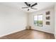 An empty bedroom has a ceiling fan and a large window overlooking the exterior at 11891 N 147Th Dr, Surprise, AZ 85379