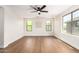Well-lit, spacious bedroom featuring hardwood floors, a modern ceiling fan and an array of windows for natural light at 11891 N 147Th Dr, Surprise, AZ 85379