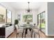 Bright dining room featuring a glass-top table, stylish light fixture, and a sliding door for seamless indoor/outdoor living at 11891 N 147Th Dr, Surprise, AZ 85379