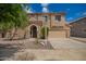 Charming two-story home featuring a well-manicured front yard and a welcoming, covered entry with an arched doorway at 11891 N 147Th Dr, Surprise, AZ 85379