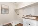 Bright laundry room features white cabinets, sink, and storage shelf at 11891 N 147Th Dr, Surprise, AZ 85379