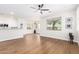 Open living room with light hardwood floors, ceiling fan, and large windows for natural light at 11891 N 147Th Dr, Surprise, AZ 85379