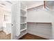 Bright walk-in closet features wood floor, custom shelving, and multiple hanging racks at 11891 N 147Th Dr, Surprise, AZ 85379