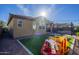 Landscaped backyard with artificial turf, patio area, and play equipment, perfect for outdoor fun at 13140 W Rowel Rd, Peoria, AZ 85383