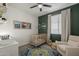 Bedroom with a wooden crib, a comfortable chair, and a decorative rug on the floor at 13140 W Rowel Rd, Peoria, AZ 85383