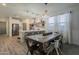 Bright dining space with a large wooden table, modern chairs, and a view into the modern kitchen at 13140 W Rowel Rd, Peoria, AZ 85383