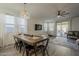 Bright dining area featuring a wooden table, modern light fixture, and open access to the outdoor patio at 13140 W Rowel Rd, Peoria, AZ 85383