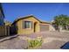 A single-story tan home with desert landscaping and a paver driveway at 13140 W Rowel Rd, Peoria, AZ 85383