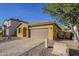 A tan stucco home with a two car garage and paver driveway at 13140 W Rowel Rd, Peoria, AZ 85383