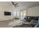 Spacious living room with a plush sectional sofa, stylish rug, and easy access to the outdoor space at 13140 W Rowel Rd, Peoria, AZ 85383