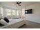 Spacious main bedroom with a large window, sleek ceiling fan, and ensuite bathroom at 13140 W Rowel Rd, Peoria, AZ 85383
