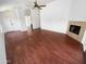 Open-concept living room with wood floors, a fireplace, and ample natural light at 14065 W Cornerstone Trl, Surprise, AZ 85374