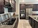 Modern kitchen featuring stainless steel appliances, granite countertops, and dark wood cabinetry at 15301 W Moreland St, Goodyear, AZ 85338