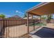 Inviting backyard featuring a covered patio, sparkling pool, and privacy fencing at 15725 W Lundberg St, Surprise, AZ 85374