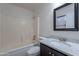 Cozy bathroom featuring a shower-tub combo, dark vanity with granite, and a large mirror at 15725 W Lundberg St, Surprise, AZ 85374