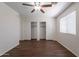 Bedroom boasts wood-look flooring, a ceiling fan, a window with blinds, and a double sliding door closet with shelving at 15725 W Lundberg St, Surprise, AZ 85374