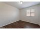 Bright bedroom featuring wood-look floors and a window with blinds at 15725 W Lundberg St, Surprise, AZ 85374