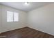 Bright bedroom featuring wood-look floors, a window with blinds, and ample natural light at 15725 W Lundberg St, Surprise, AZ 85374