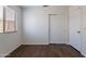 Bright bedroom featuring wood-look floors, a window with blinds, and neutral walls at 15725 W Lundberg St, Surprise, AZ 85374