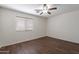 Bedroom with wood-look flooring, window with blinds, and modern ceiling fan at 15725 W Lundberg St, Surprise, AZ 85374