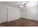 This bedroom features modern wood-look flooring, a ceiling fan, and spacious closets at 15725 W Lundberg St, Surprise, AZ 85374