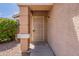 Covered front porch with a security door and beige columns at a tan house at 15725 W Lundberg St, Surprise, AZ 85374