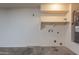 Garage interior showing white walls, water heater, storage nook and cement flooring at 15725 W Lundberg St, Surprise, AZ 85374