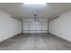 Spacious garage with automatic door and ample room for vehicles and storage, plus concrete floors at 15725 W Lundberg St, Surprise, AZ 85374