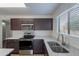 An open concept kitchen with gray countertops, a stainless steel sink, and stainless steel appliances at 15725 W Lundberg St, Surprise, AZ 85374