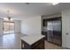 A kitchen with stainless steel appliances, an island, and a view of the living room and backyard at 15725 W Lundberg St, Surprise, AZ 85374