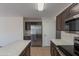 A kitchen offering stainless steel appliances, dark cabinets, an island, and neutral tile flooring at 15725 W Lundberg St, Surprise, AZ 85374